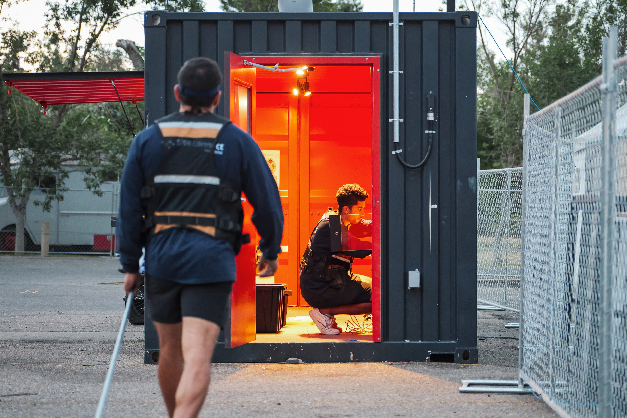 A connectivity experts works on a panel while another person walks towards him